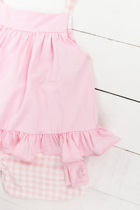 a pink dress and diaper on a white wooden floor