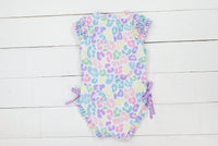 a baby girl's swimsuit on a white wall