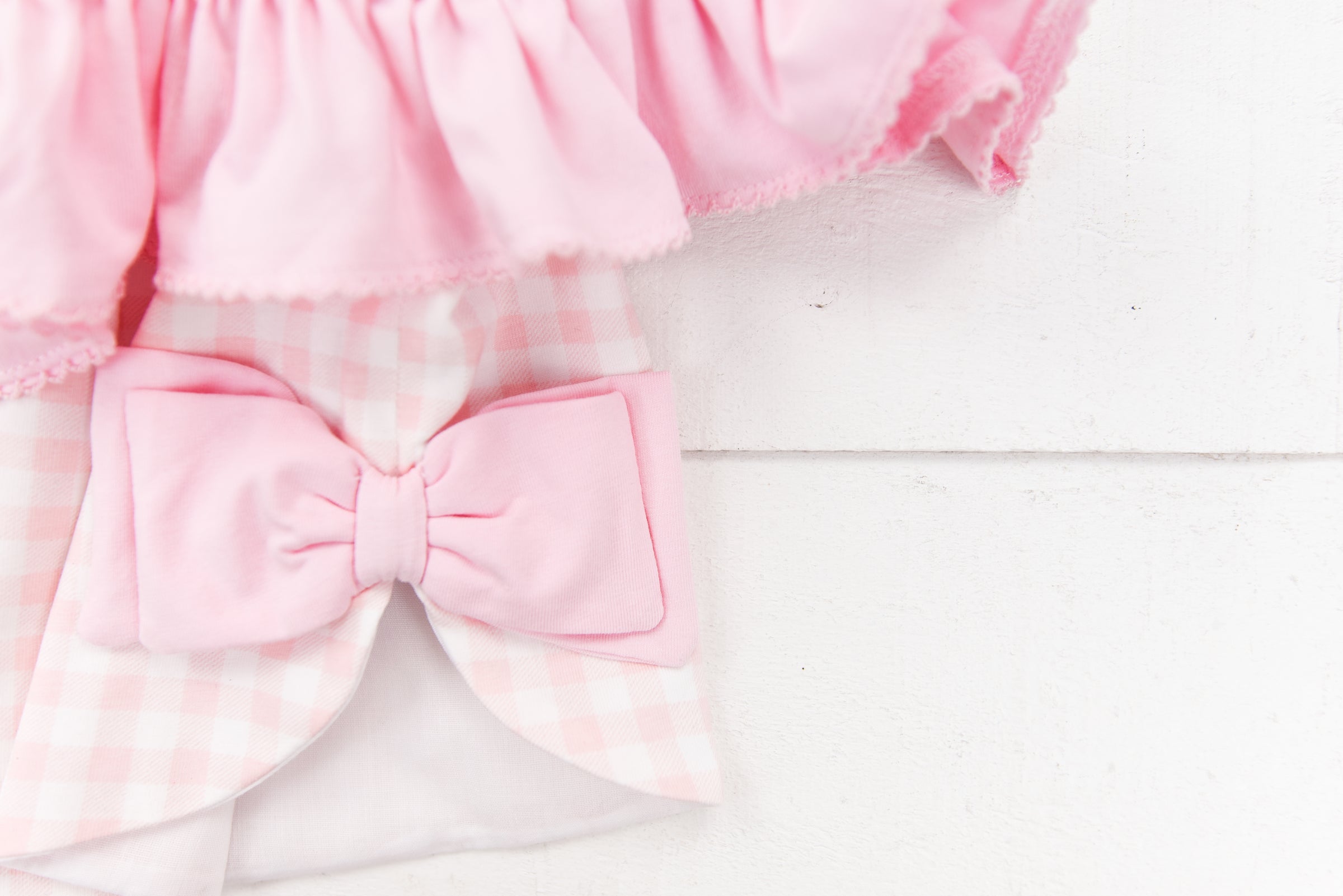 a pink and white checkered outfit with a pink bow