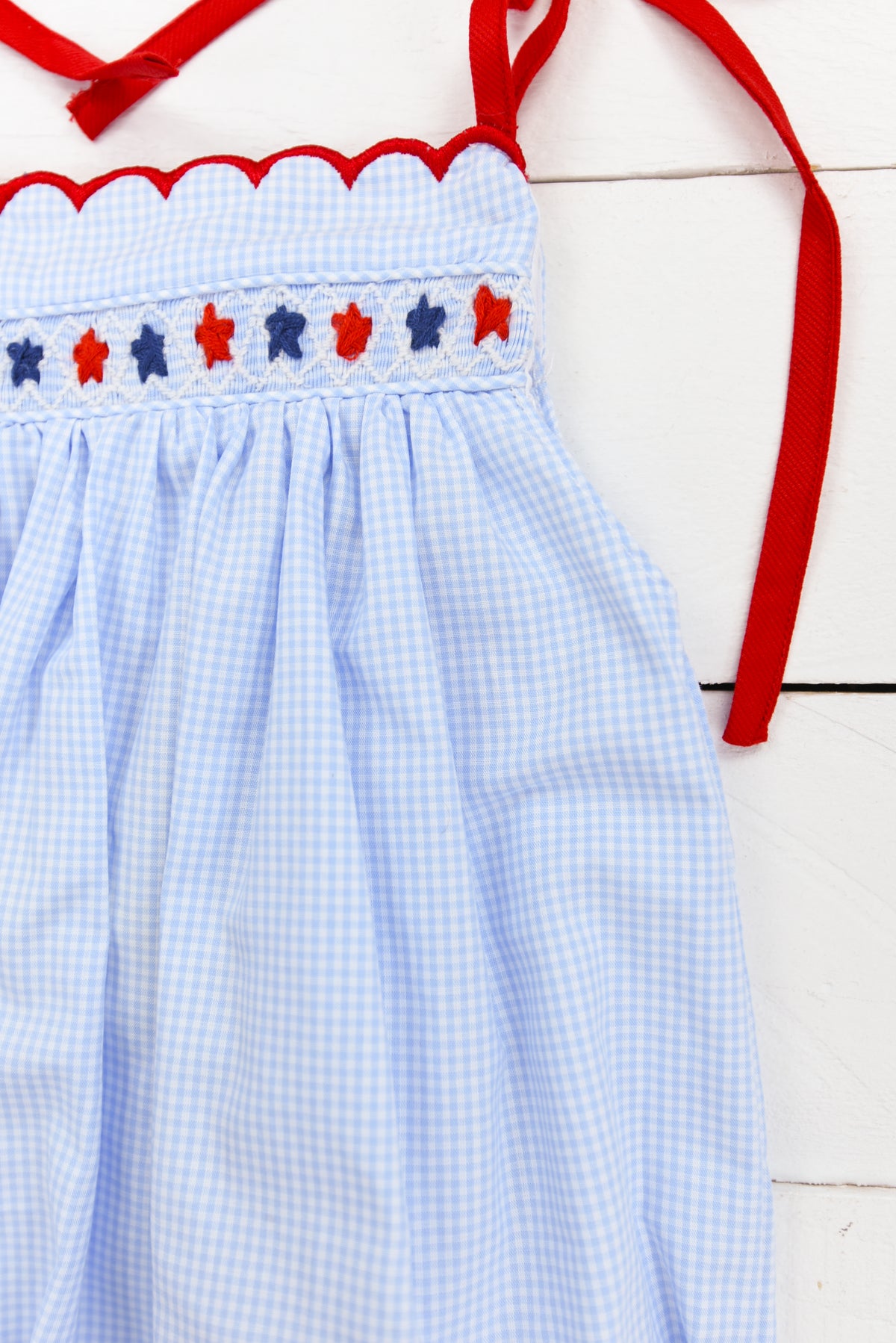 a blue and white checkered dress with red bows