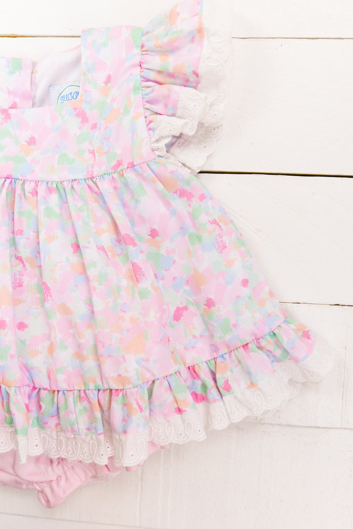 a baby girl's dress and diaper on a white background