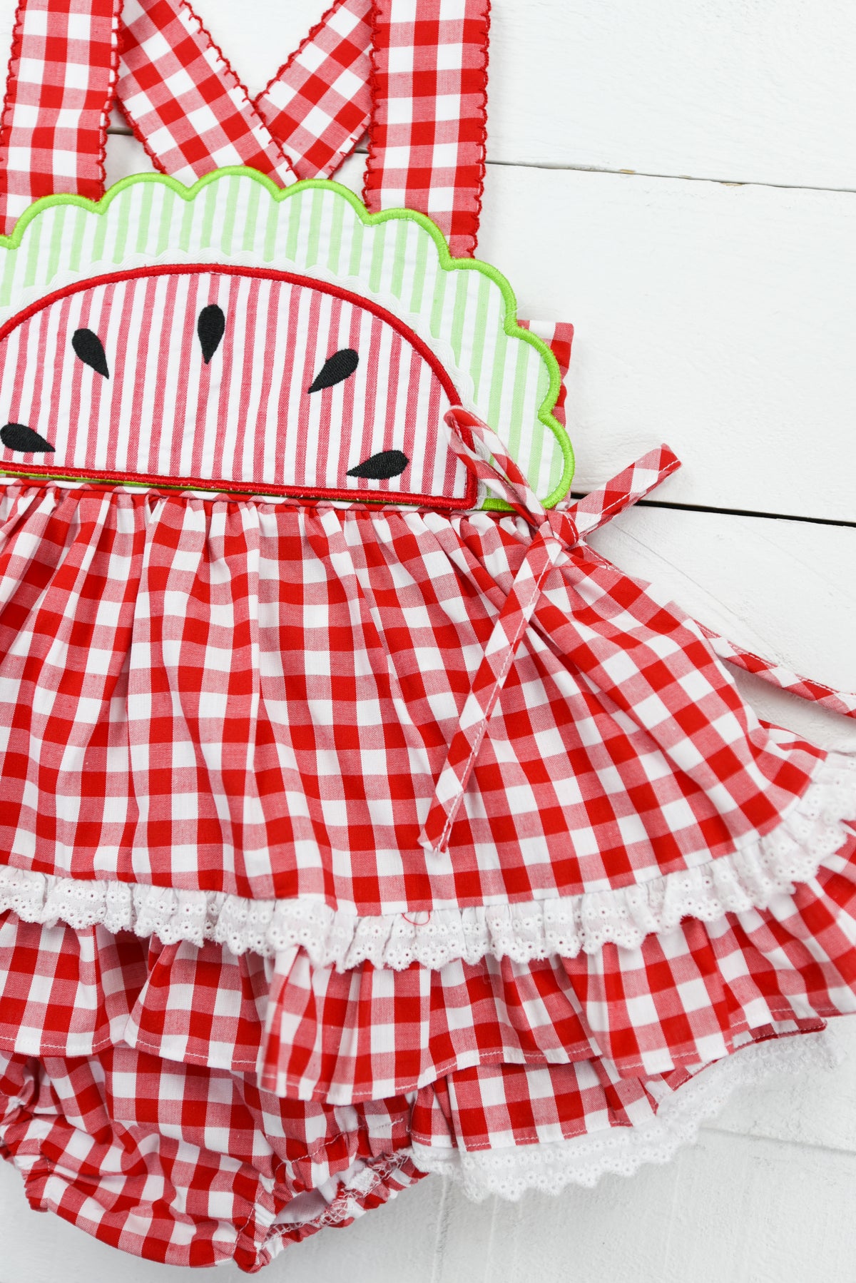 a red and white checkered dress with a green applique