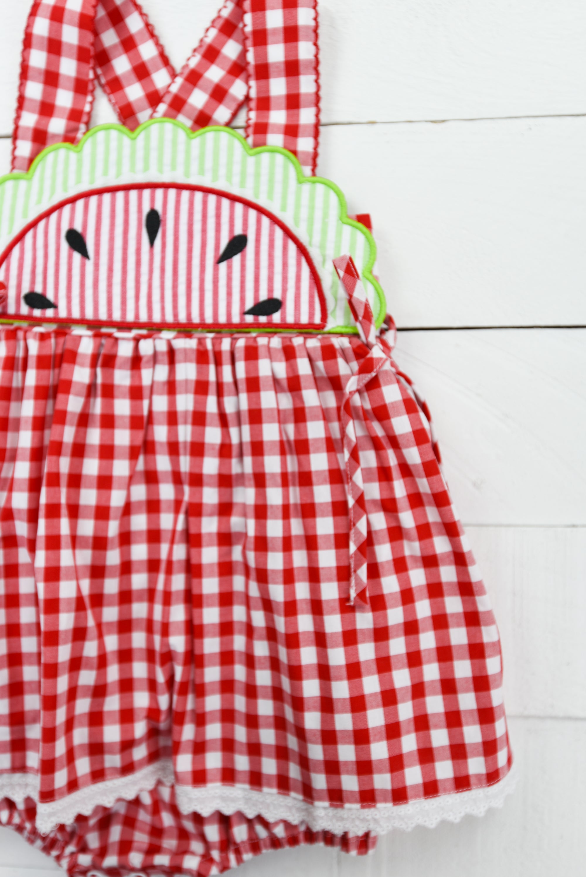 a red and white checkered romper with a green face