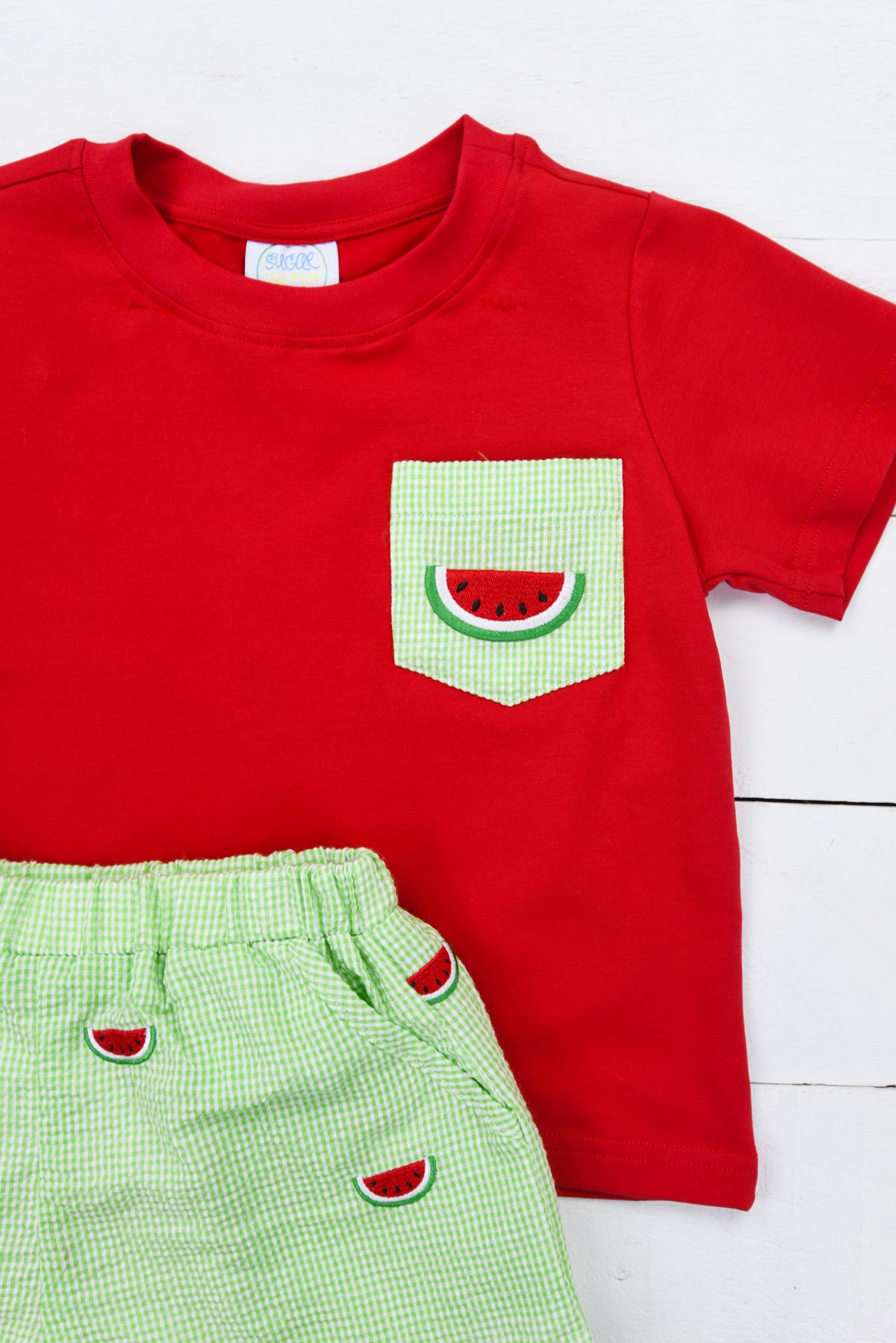 a red shirt and green shorts with a watermelon pocket