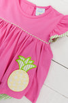 a pink dress with a pineapple applique on it